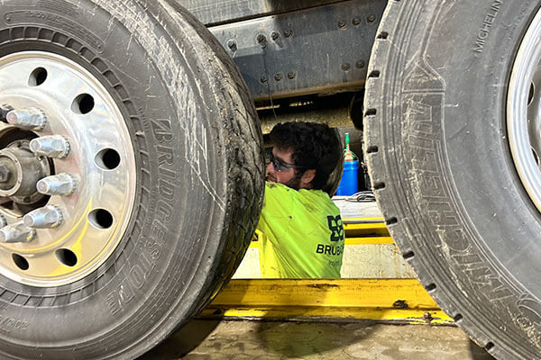 Photo of a night shift team member conducting maintenance on a truck
