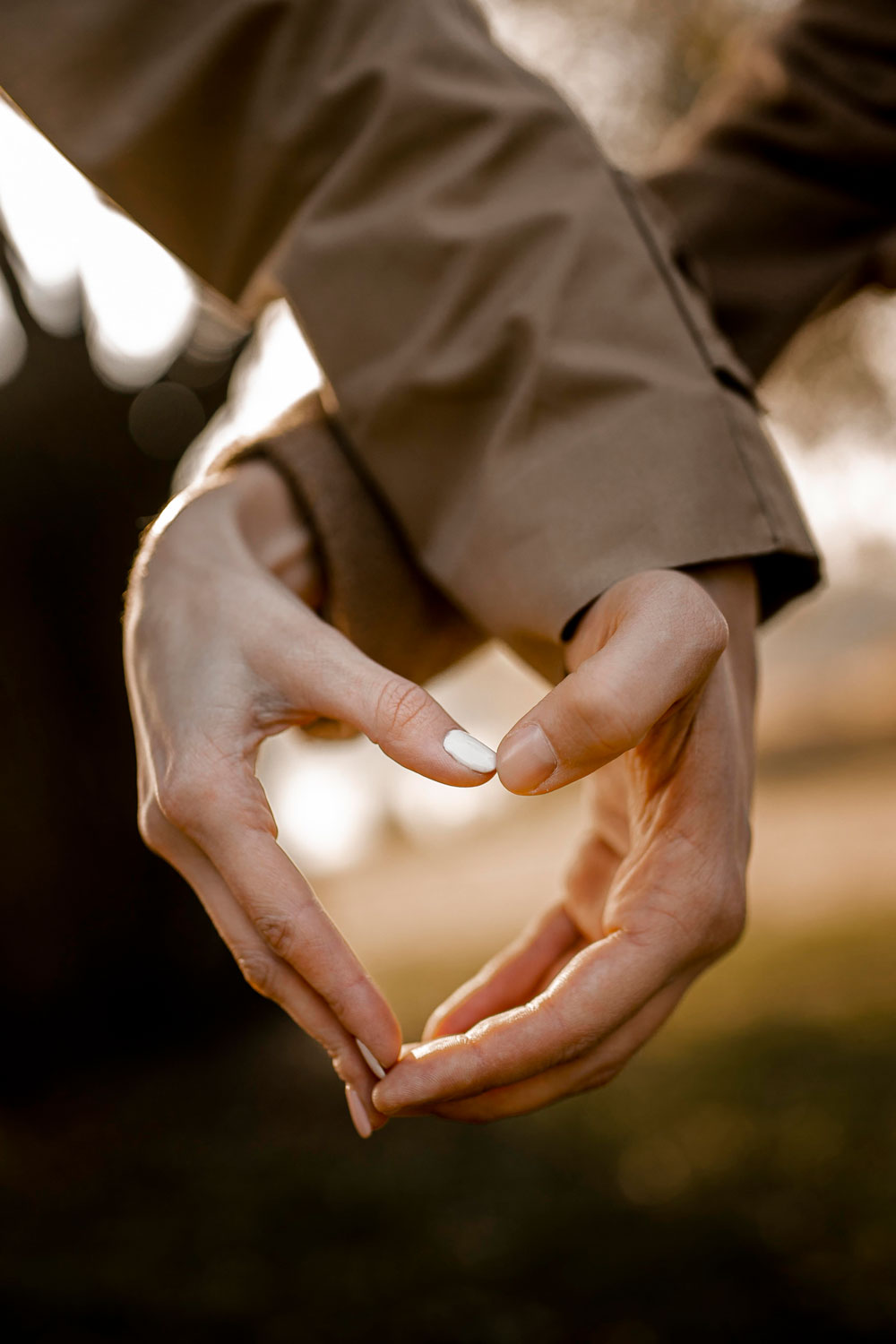 close up hands making heart shape